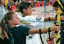 New Mexico Game & Fish educator oversees youth during archery practice.